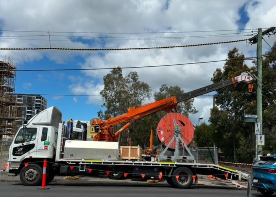 Utility truck with crane and cable reel.